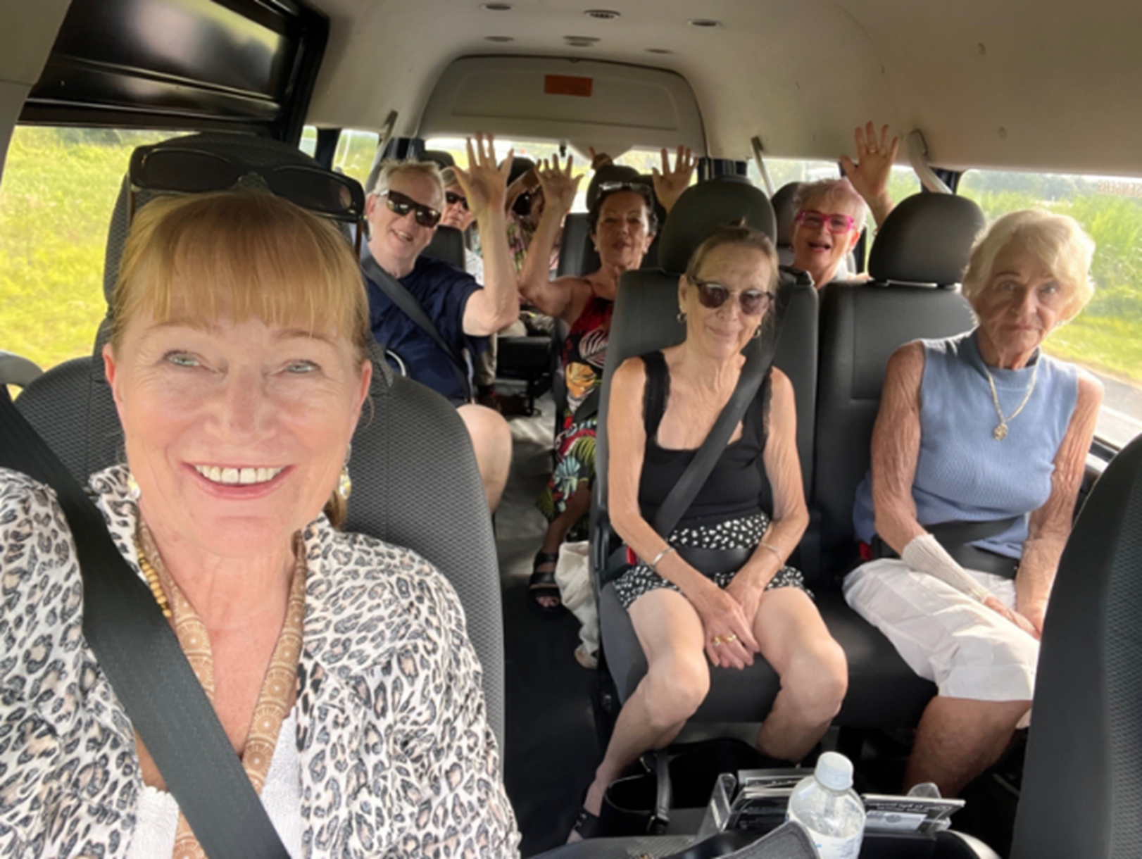 A group of people are sitting in the back seat of a van.