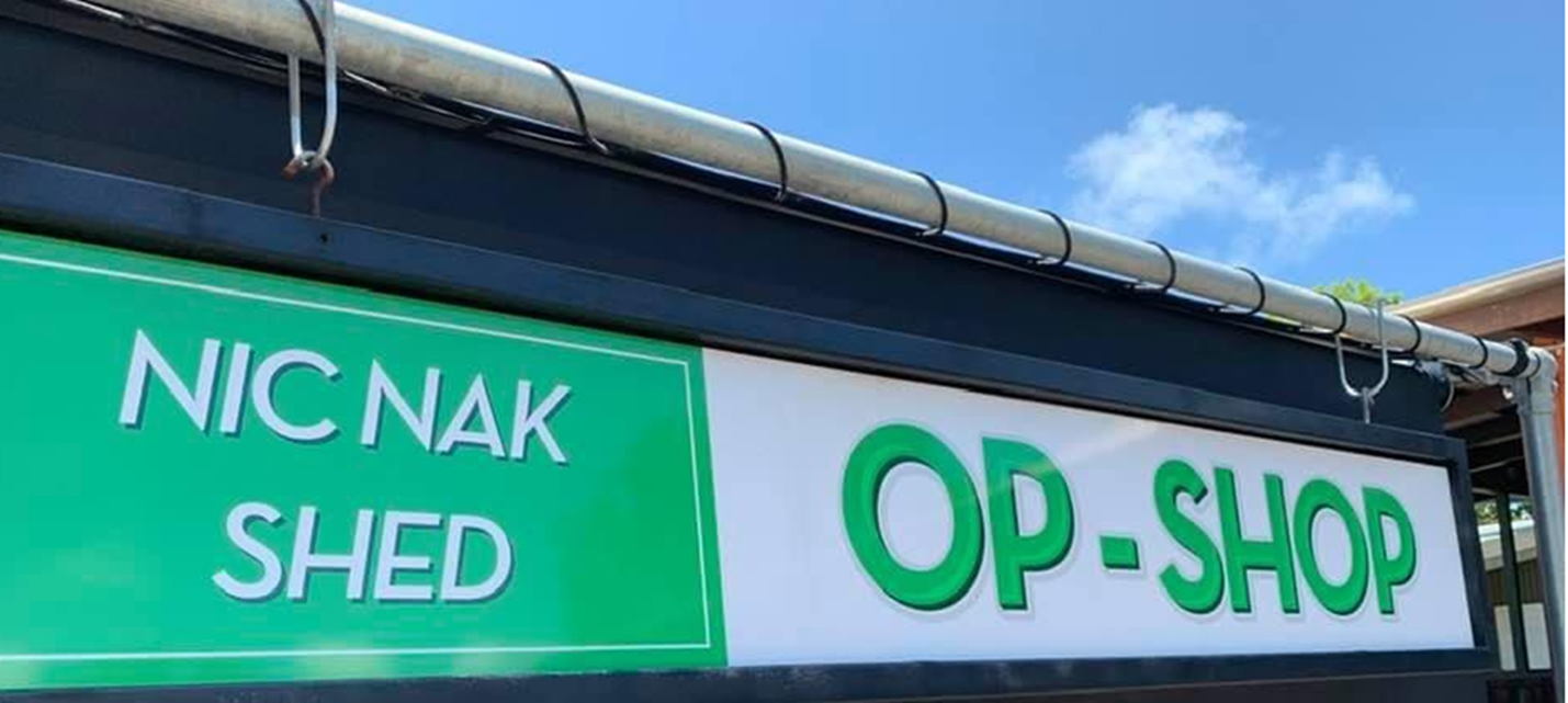 A green and white sign that says nic nak shed op shop