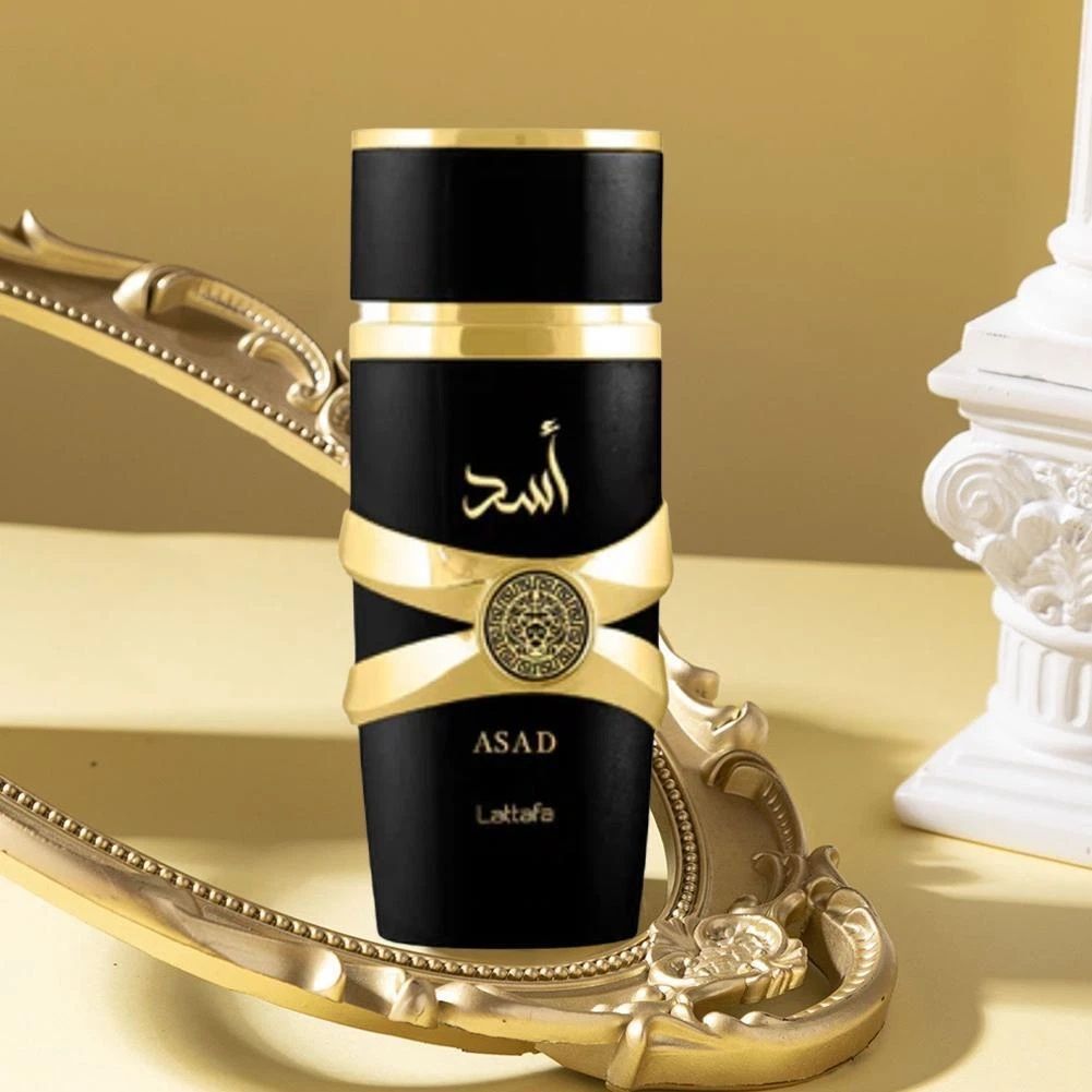 Flacone di profumo Asad nero e oro con elaborate decorazioni dorate su un vassoio decorativo dorato.