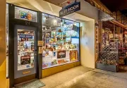 Blue Moon storefront at night with lit display windows and a sidewalk entrance