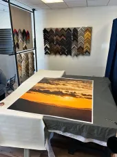 Framed sunset photo laid on a table in a frame shop with sample frames on the wall