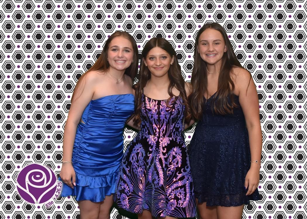 Three young women smiling in formal dresses in front of a patterned backdrop.