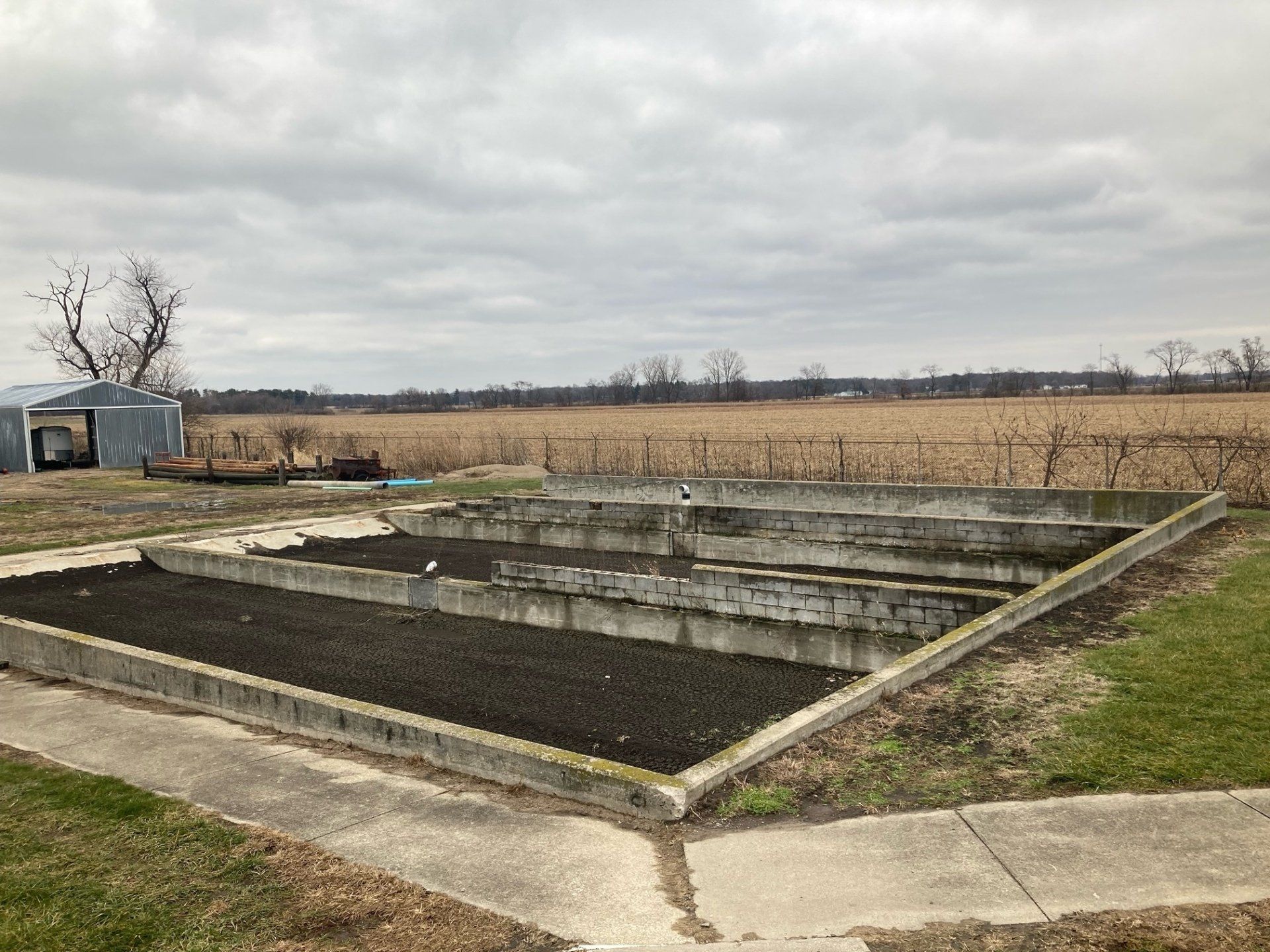 There is a large concrete structure in the middle of a field.