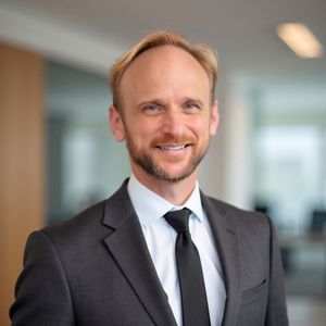 A man in a suit and tie is smiling for the camera.