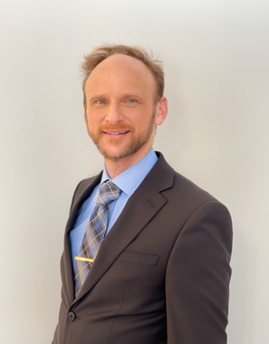 A man in a suit and tie is smiling for the camera.