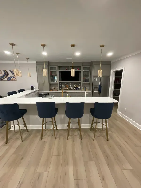 A kitchen with a bar and chairs in it.