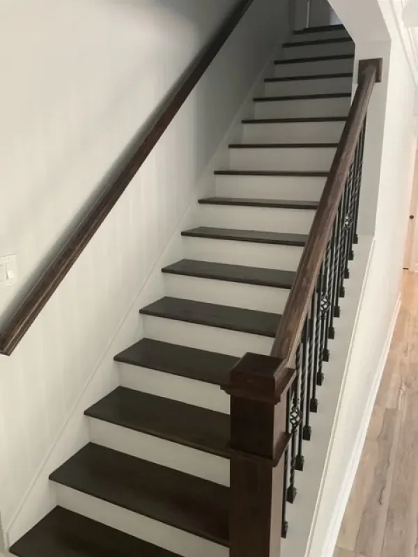 A staircase with white steps and a wooden railing