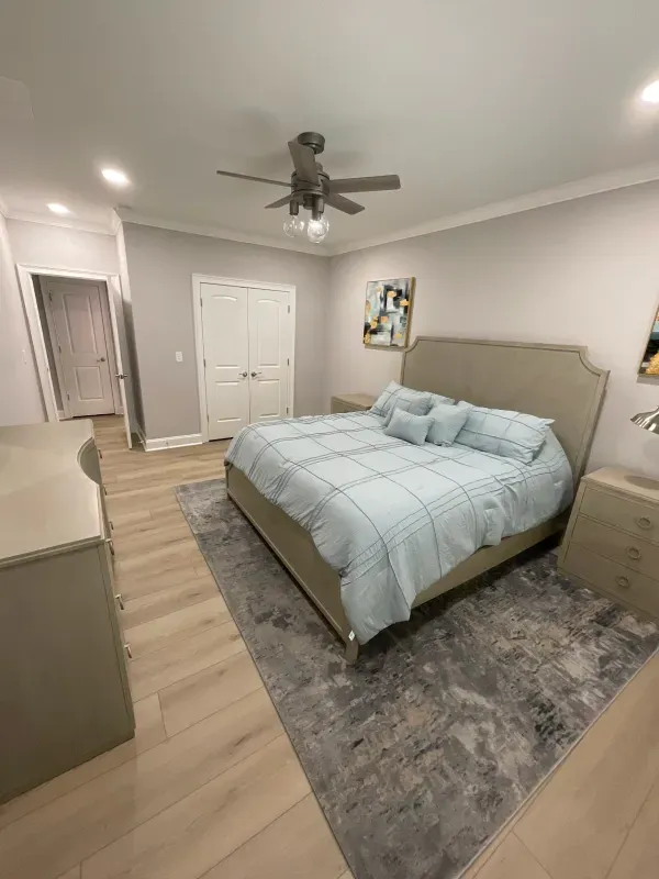 A bedroom with a king size bed and a ceiling fan.