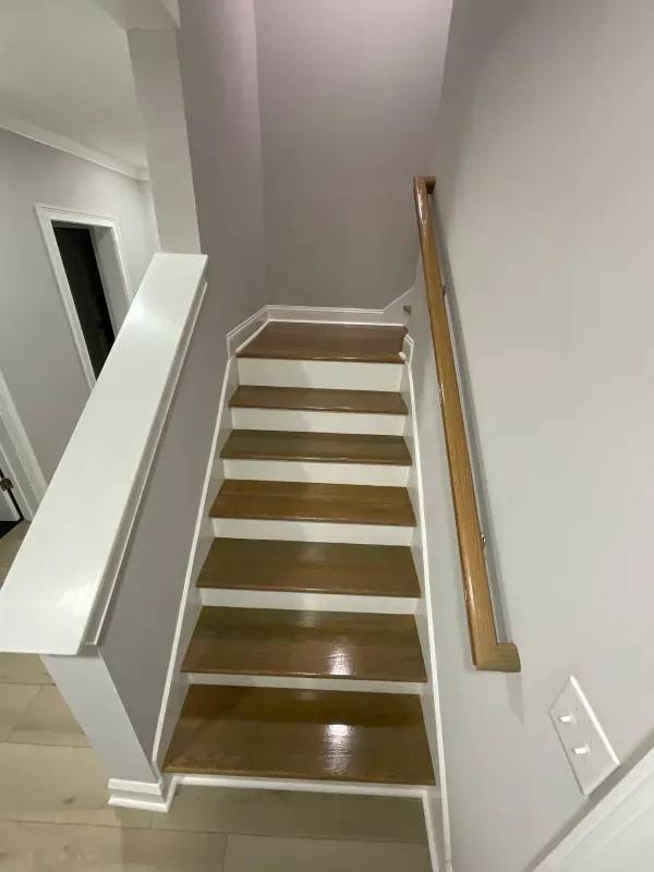 A staircase with wooden steps and a white railing in a house.
