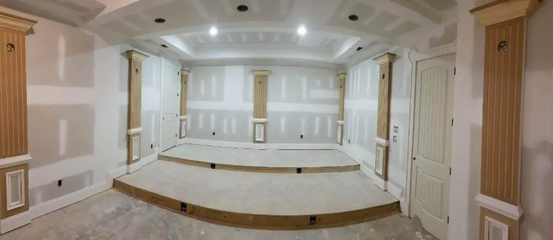 A large empty room with a stage in the middle of it.