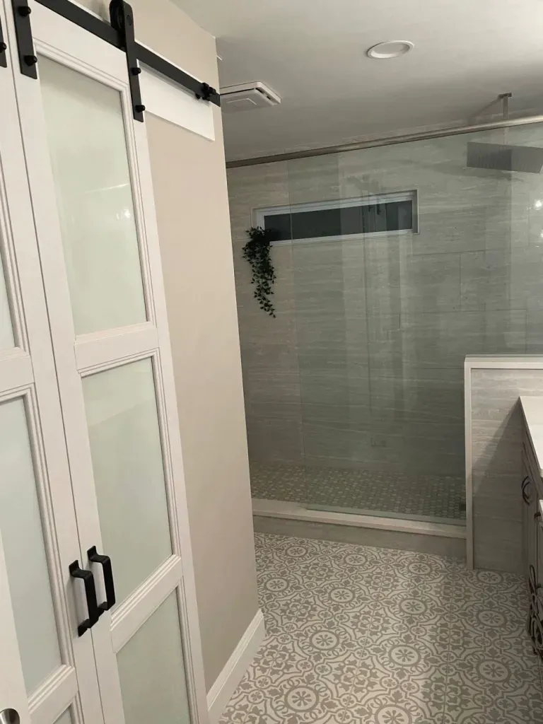 A bathroom with a sliding glass door and a walk in shower.