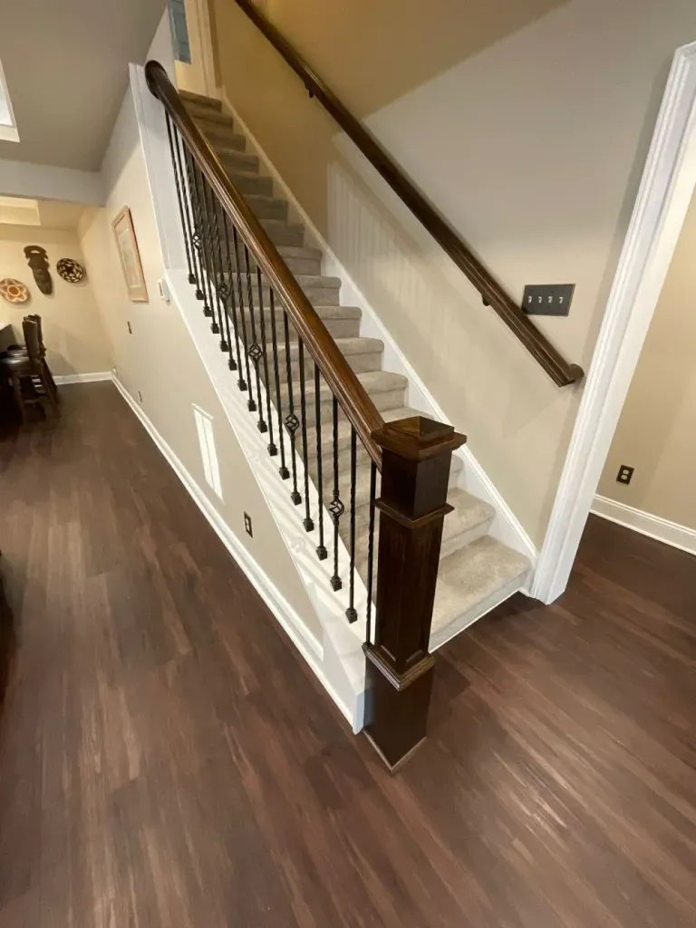 A staircase with a wooden railing and a wooden floor in a house.