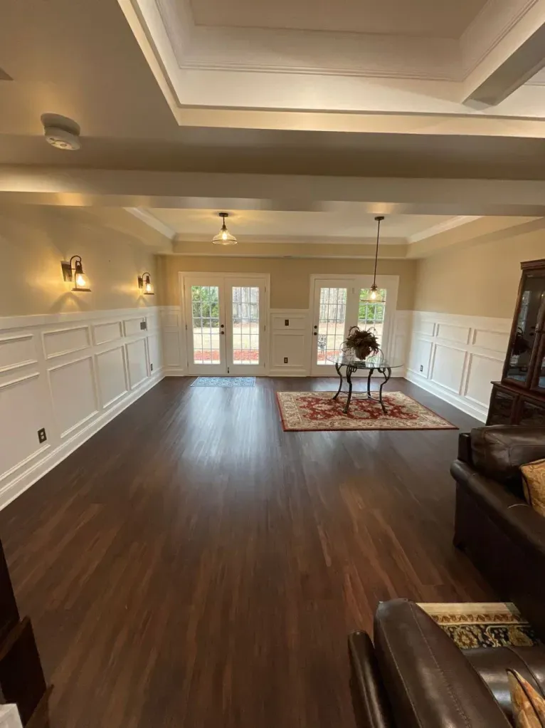 A living room with hardwood floors , a couch , a table and a rug.