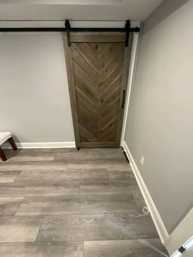 There is a sliding barn door in the corner of the room.