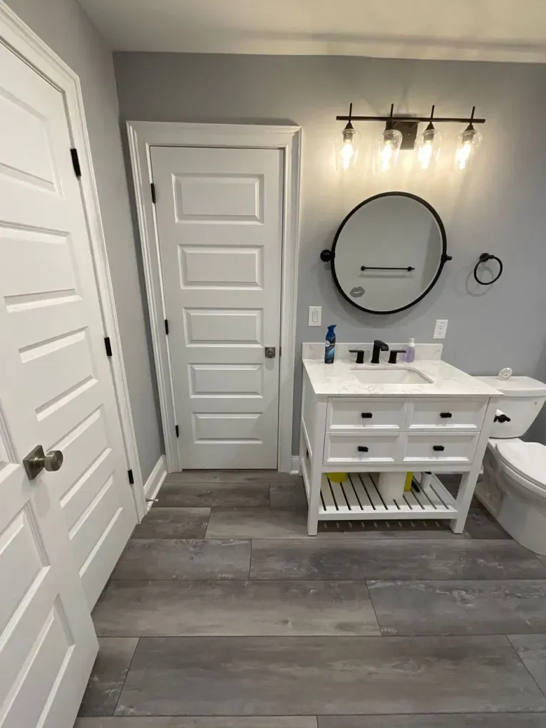 A bathroom with a sink , toilet and mirror.