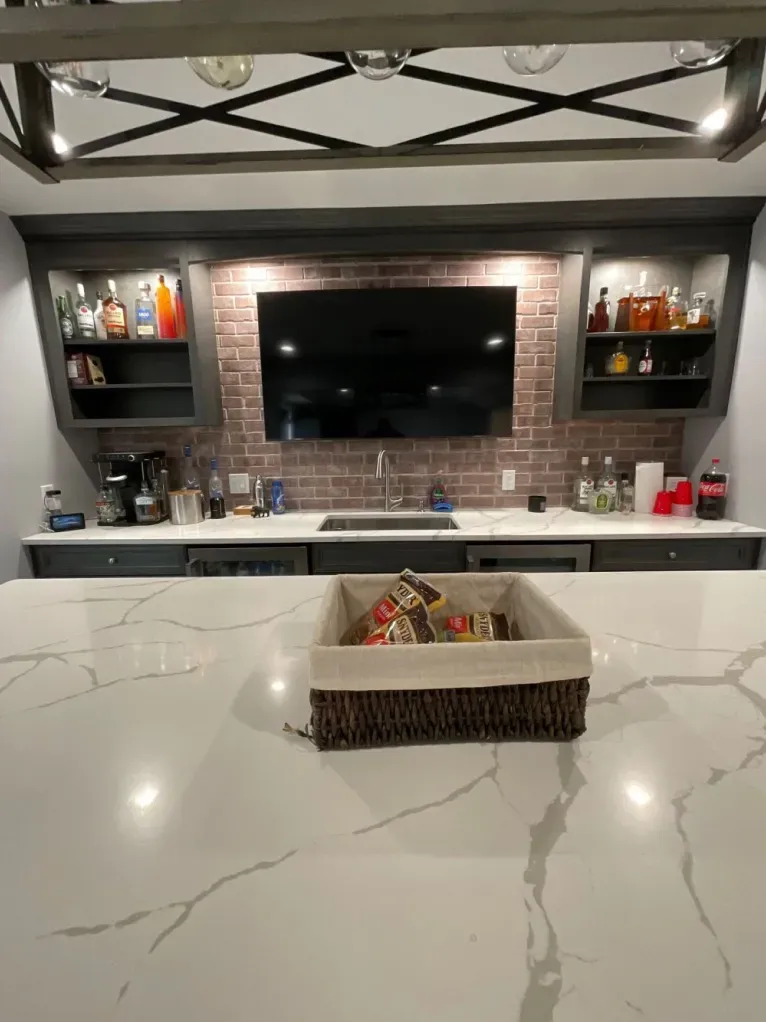 A kitchen with a tv on the wall and a basket on the counter.