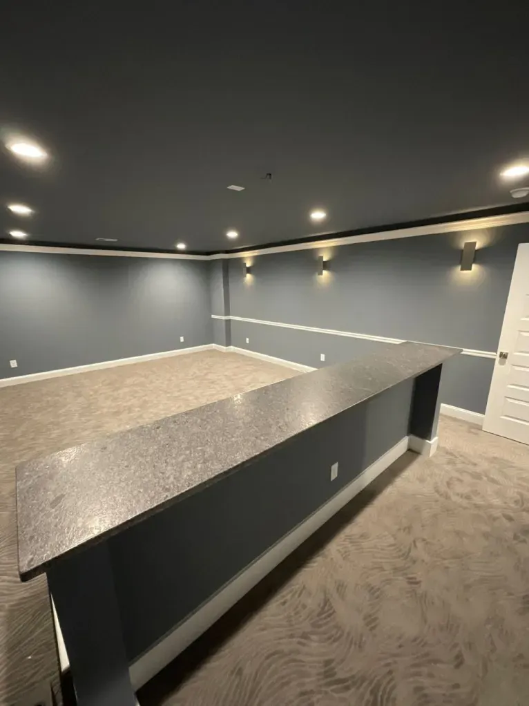 An empty basement with a large granite counter top.