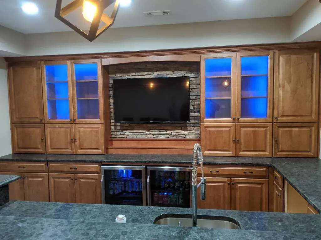 A kitchen with a sink , refrigerator , and television.