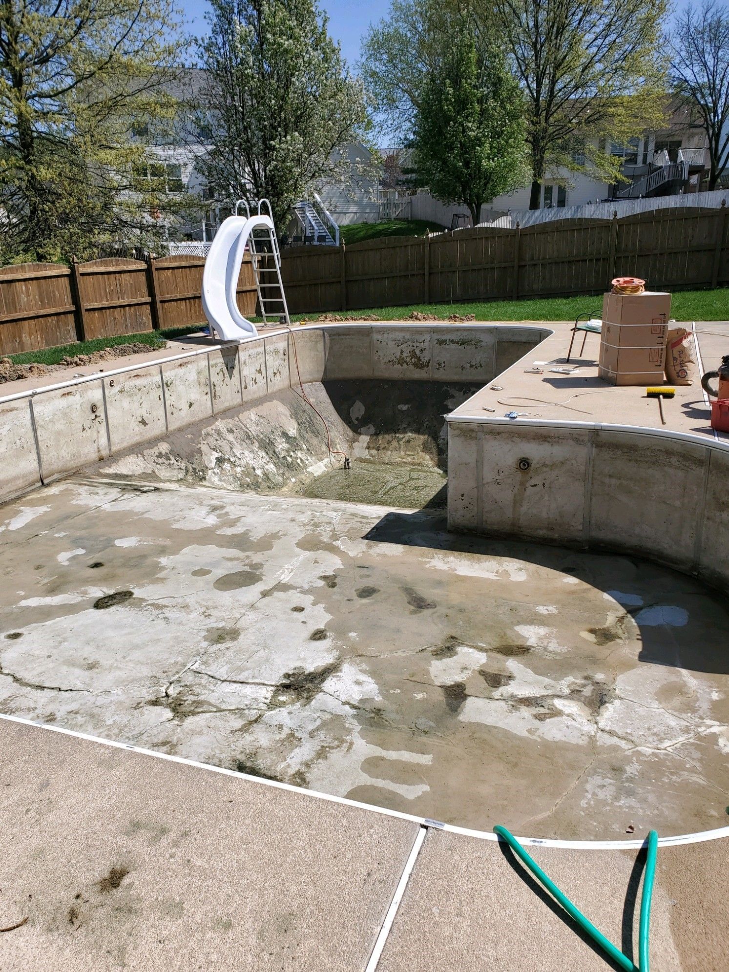 A swimming pool is being remodeled in a backyard.