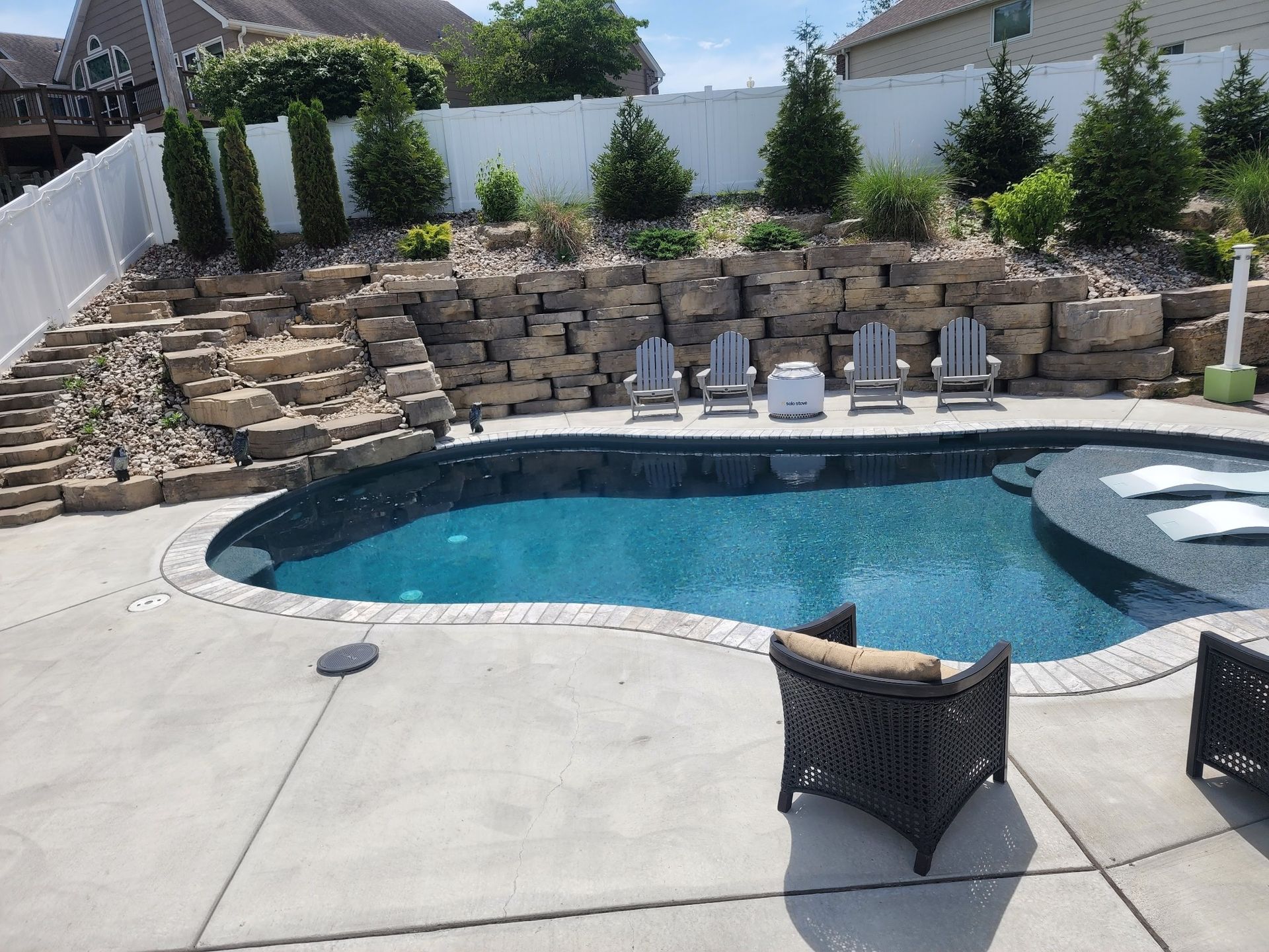 A pool with a sun ledge and a waterfall 