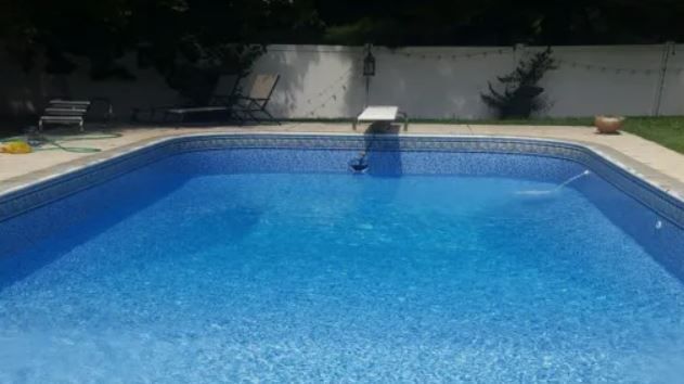 A large swimming pool with a diving board in the middle of it.