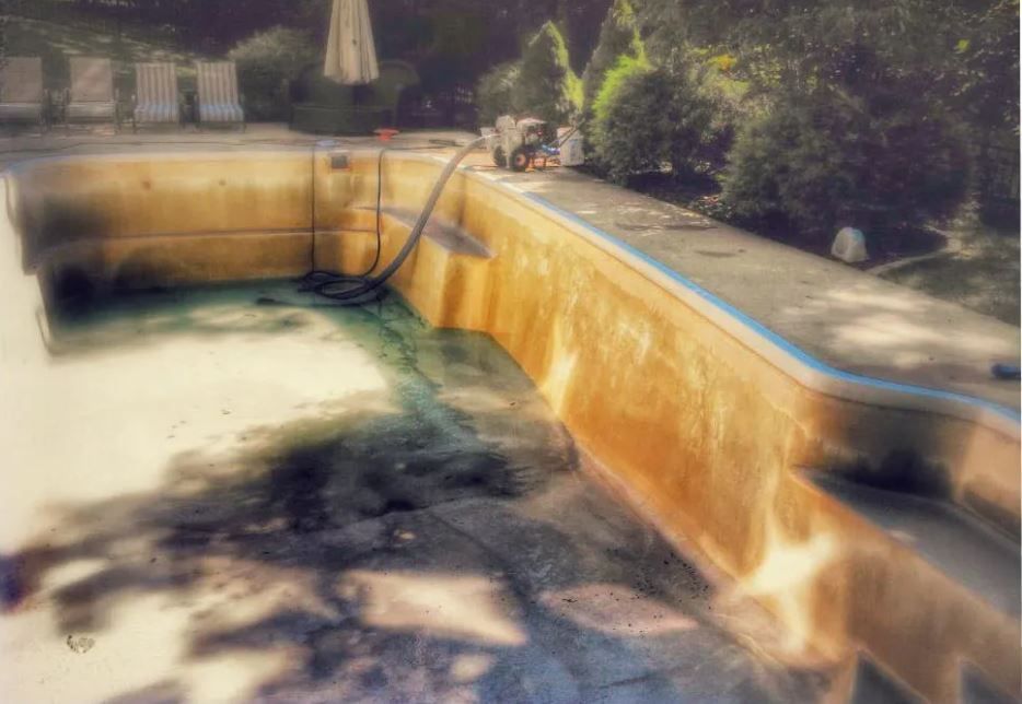 An empty swimming pool with a hose attached to it.