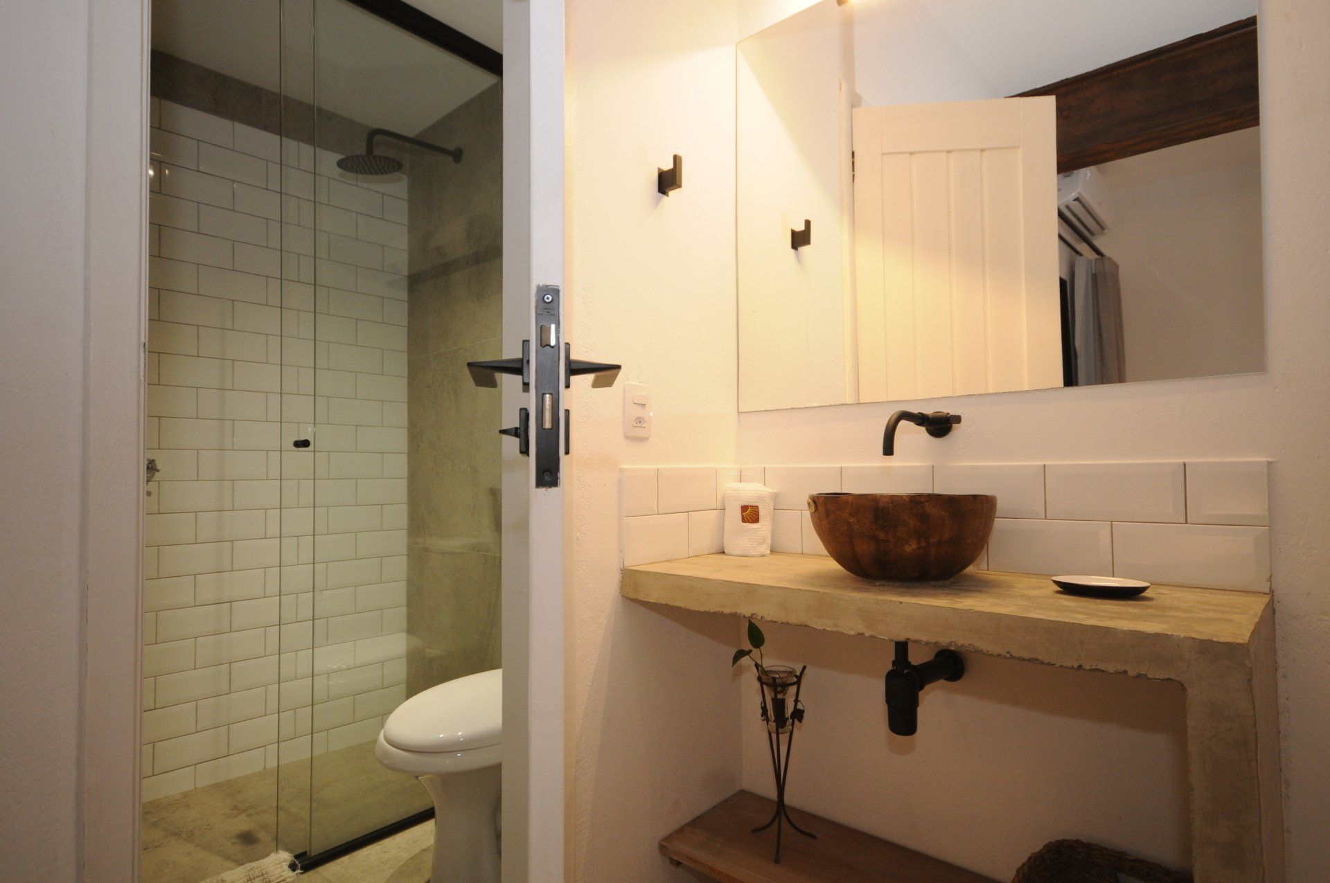 Bathroom with a wooden vanity, a bowl sink, and a glass-enclosed shower.