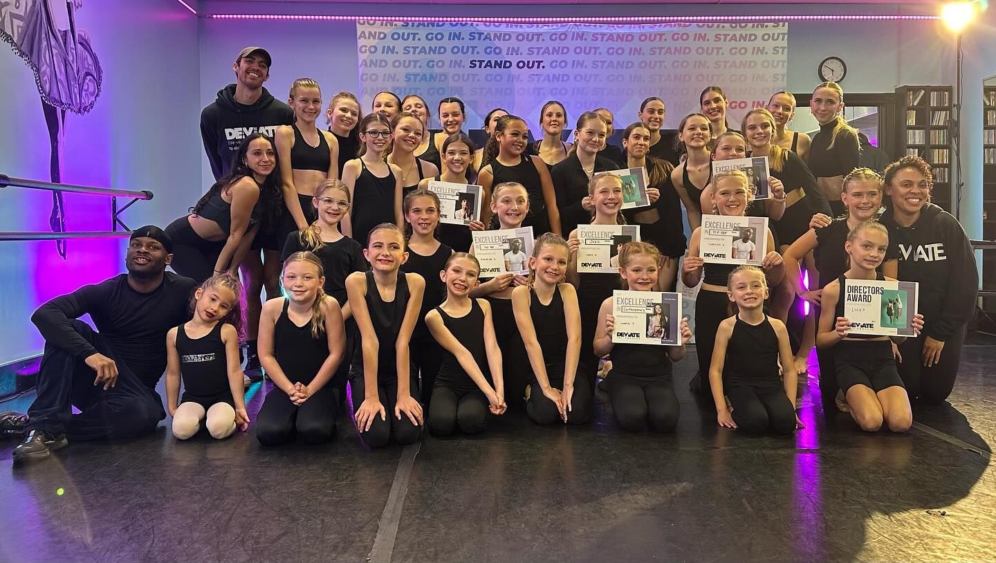 A group of young girls are posing for a picture in a dance studio.