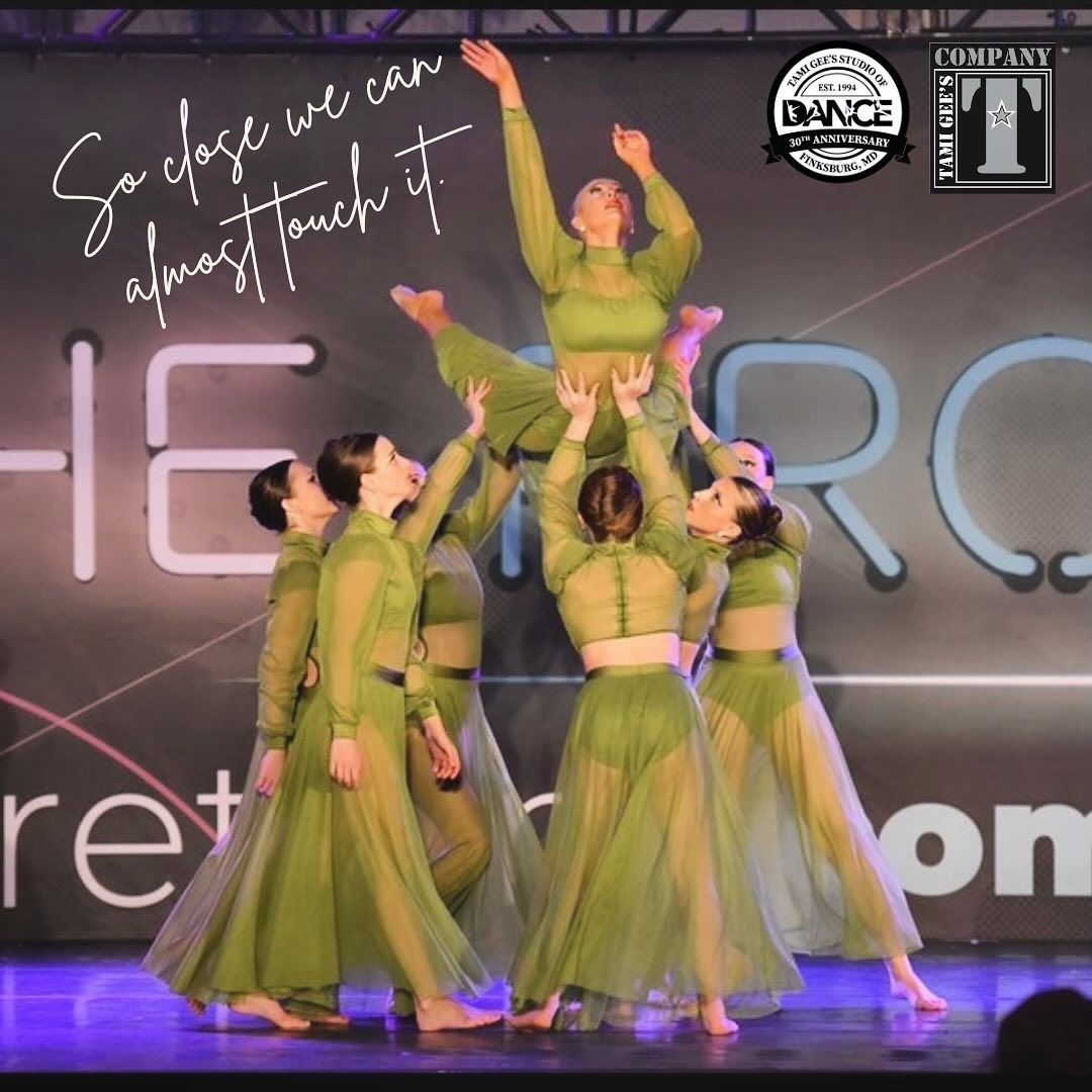 A group of women are dancing in front of a sign that says
