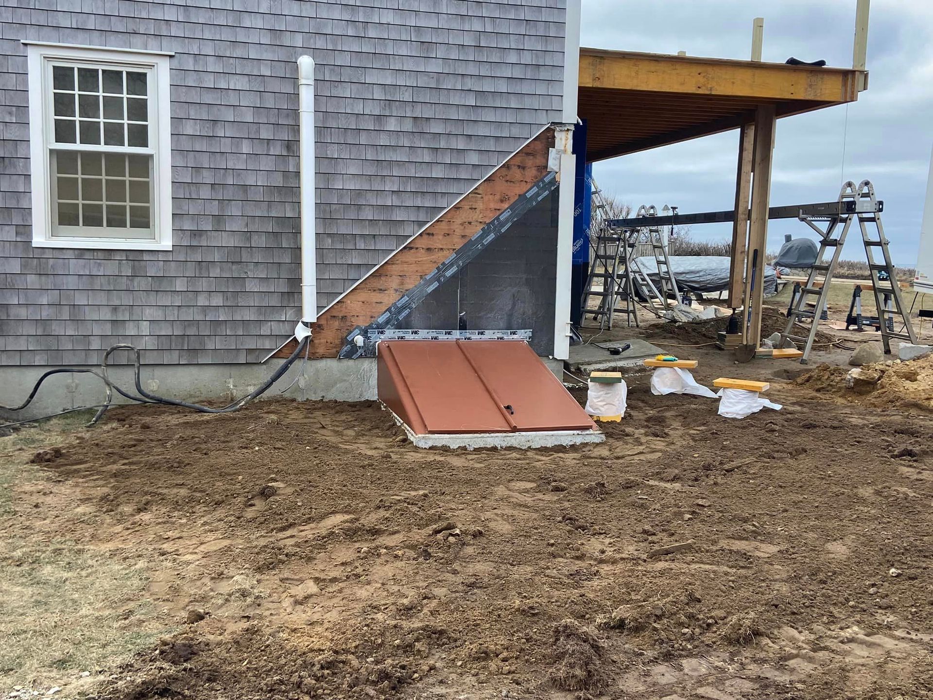 Exterior of a house with a cellar door. Construction of a deck is in progress.