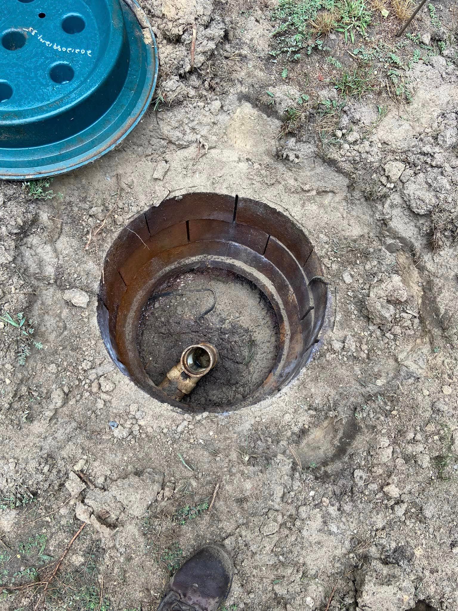Open septic tank access point with a partially removed lid.