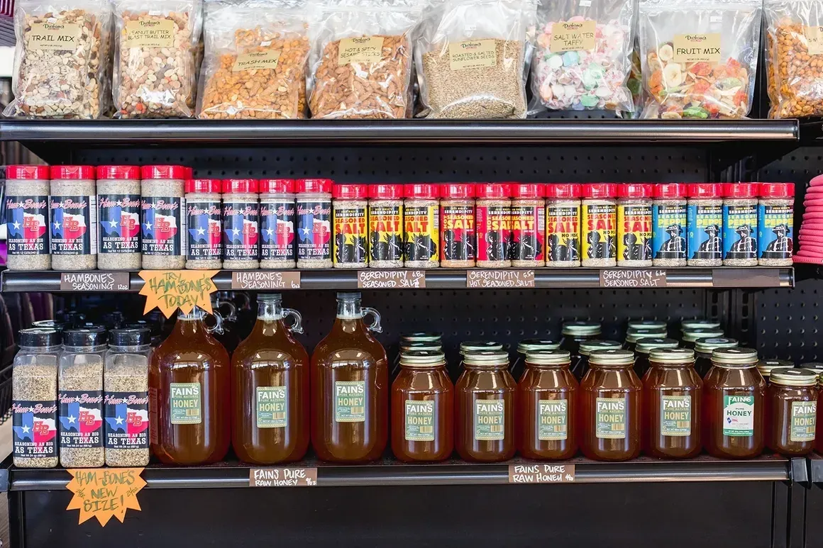 A grocery store shelf filled with jars and bags of food.