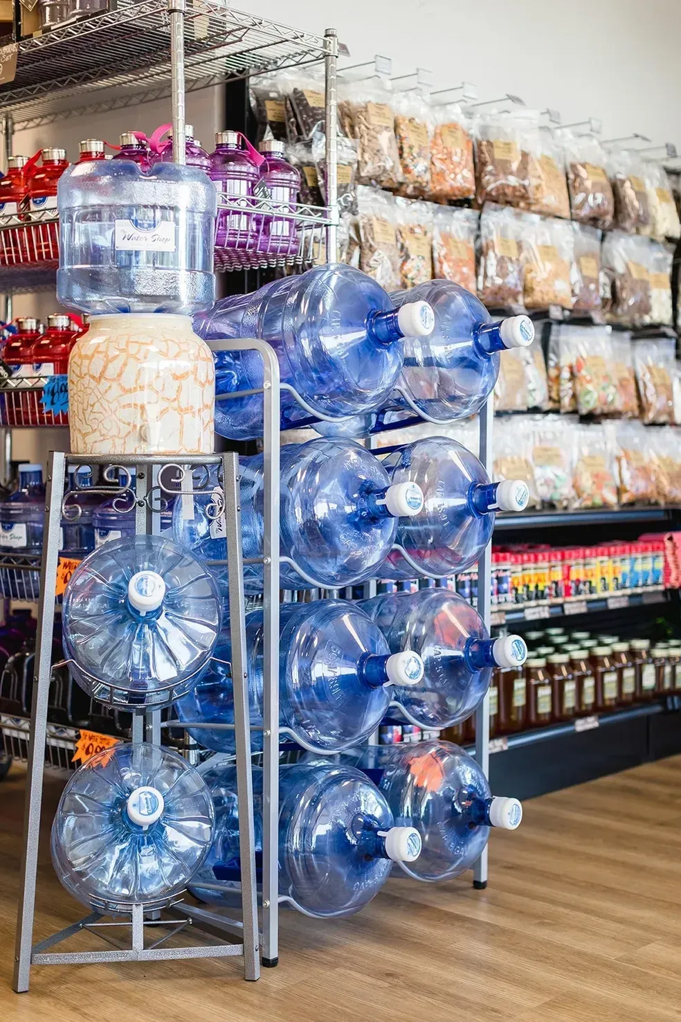 Water bottles are stacked on top of each other on a rack in a store.