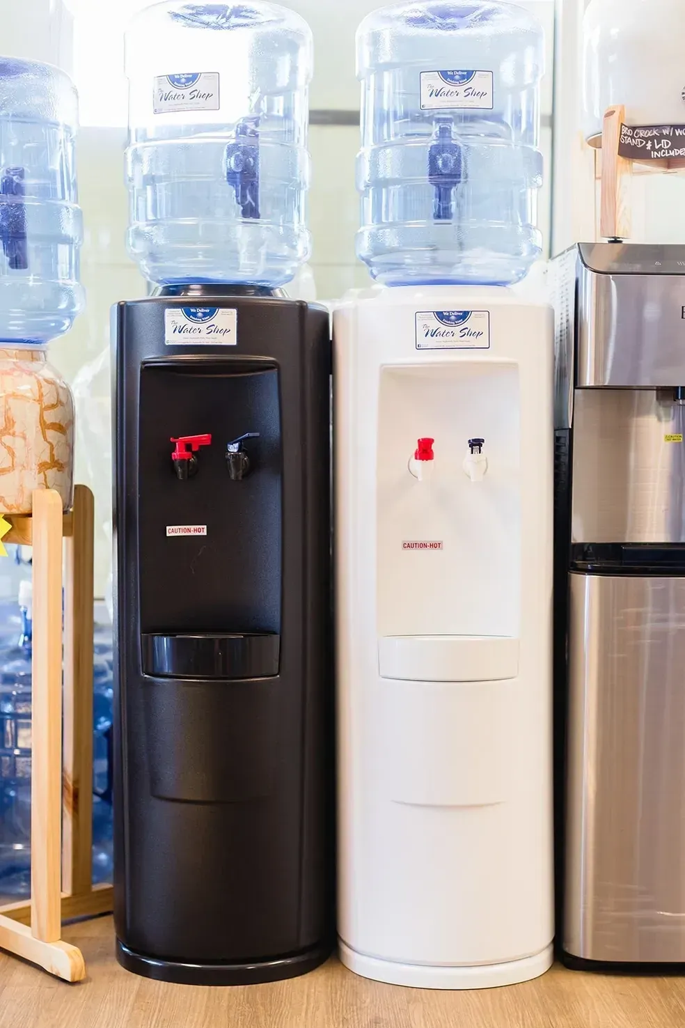 Two water dispensers are sitting next to each other in a room.