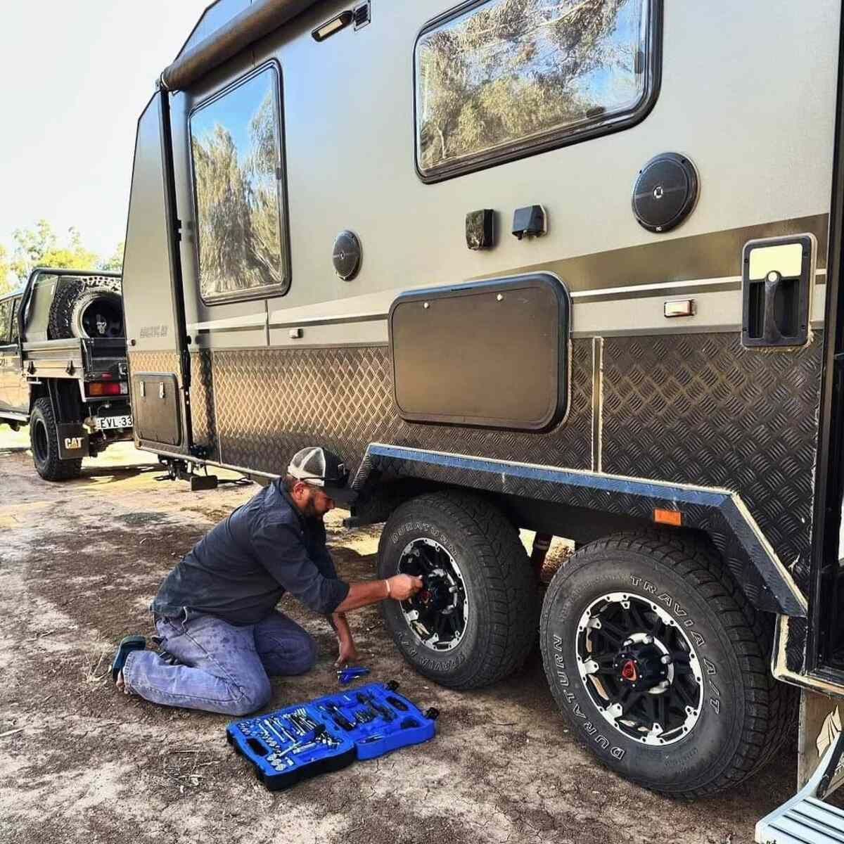 A Man Is Fixing A Tire On A Trailer — Summerland Tool Supplies In Casino, NSW