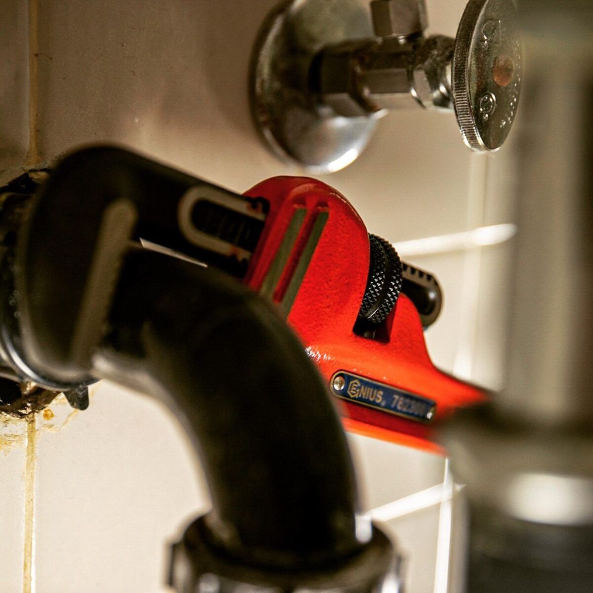 A Red Wrench Is Being Used To Fix A Faucet — Summerland Tool Supplies In Casino, NSW