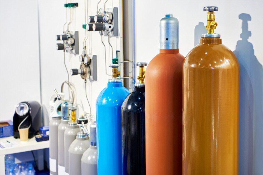 A Row Of Gas Cylinders Sitting Next To Each Other In A Room — Summerland Tool Supplies In Casino, NSW