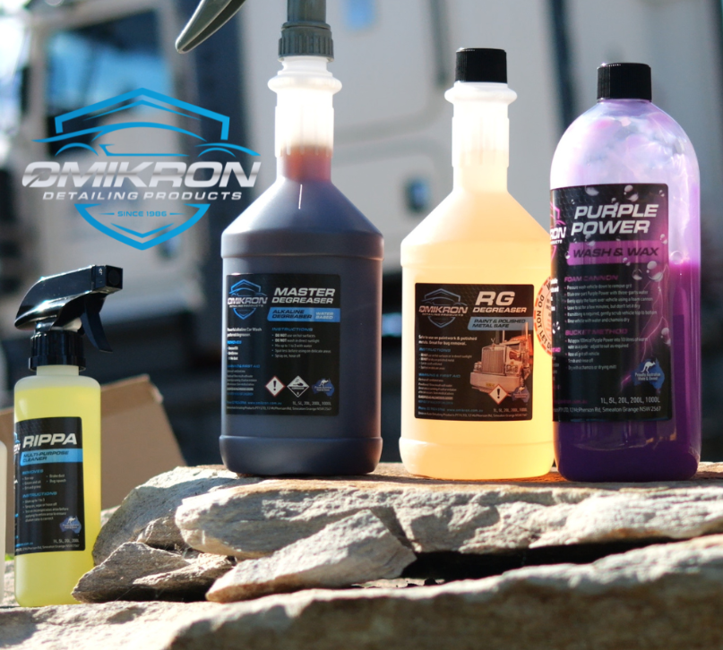 Three bottles of purple power are sitting on a rock