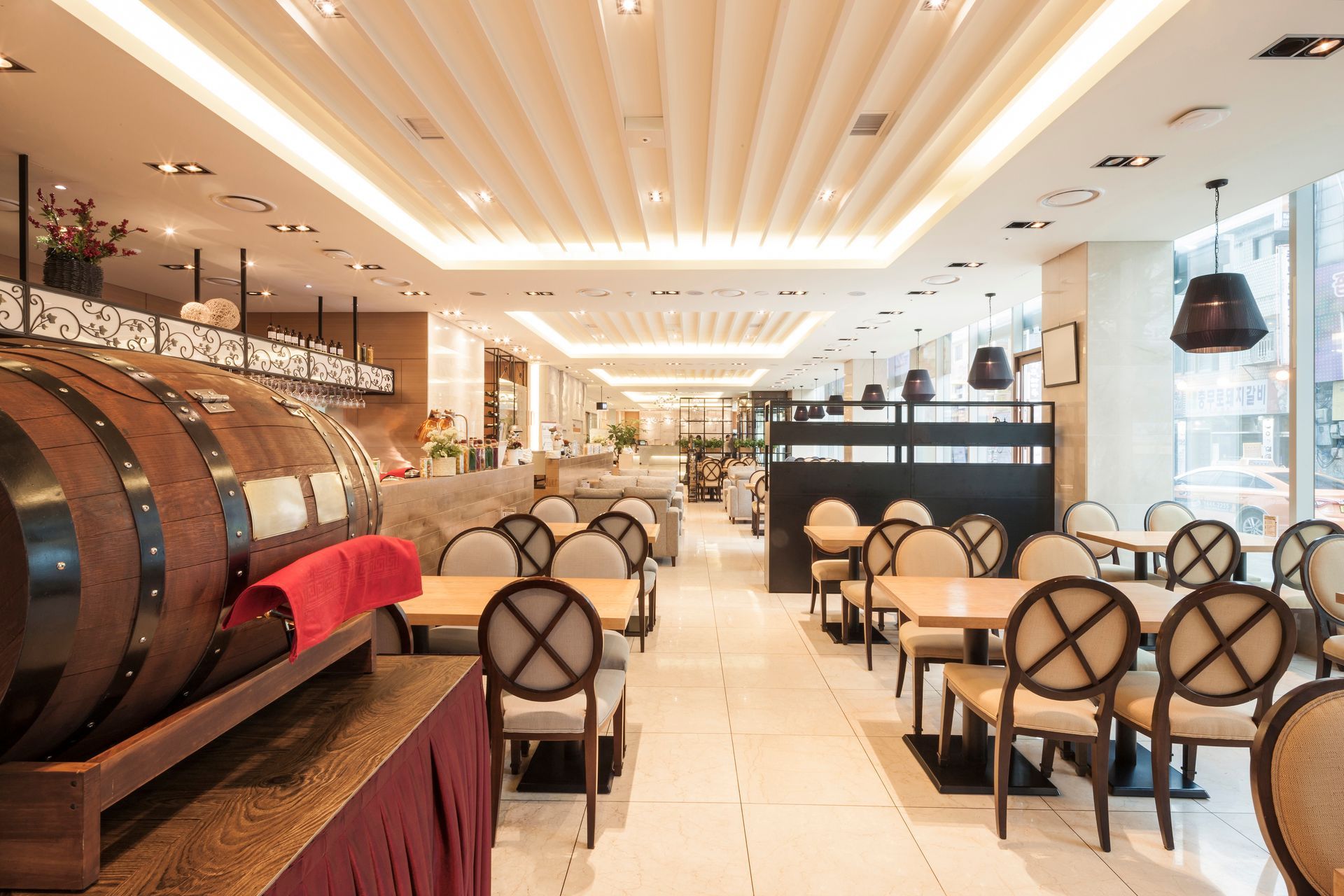 A restaurant interior featuring a large wooden barrel placed in the center of the dining area.