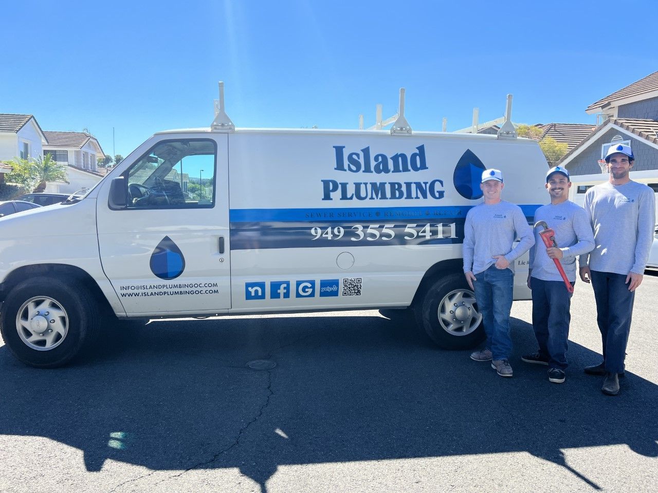 Island Plumbing van parked outdoors with three workers standing beside it