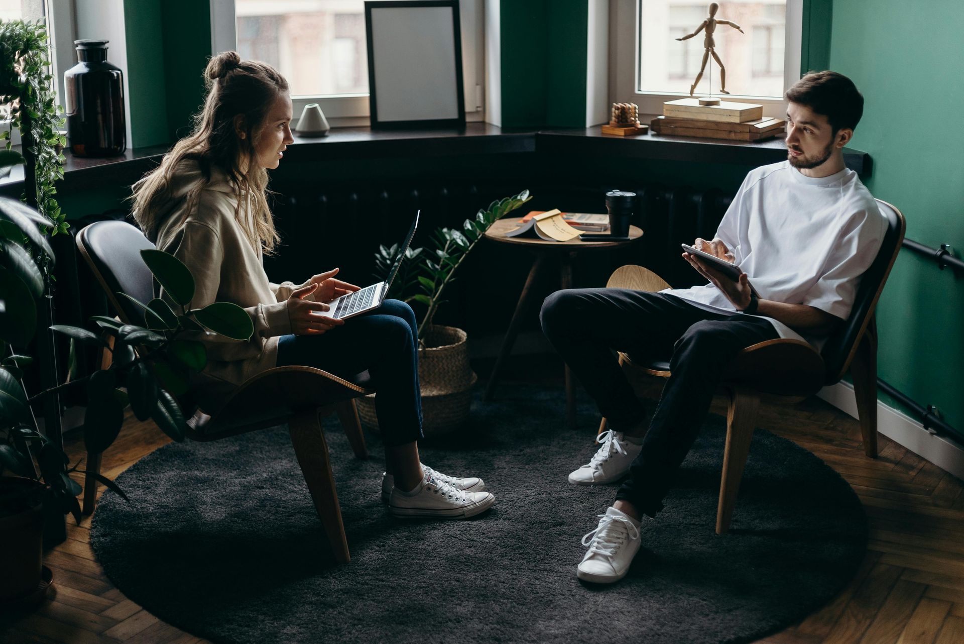 Couple working togther. Woman has a laptop, man has a food.