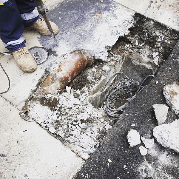 A person is working on a hole in the ground