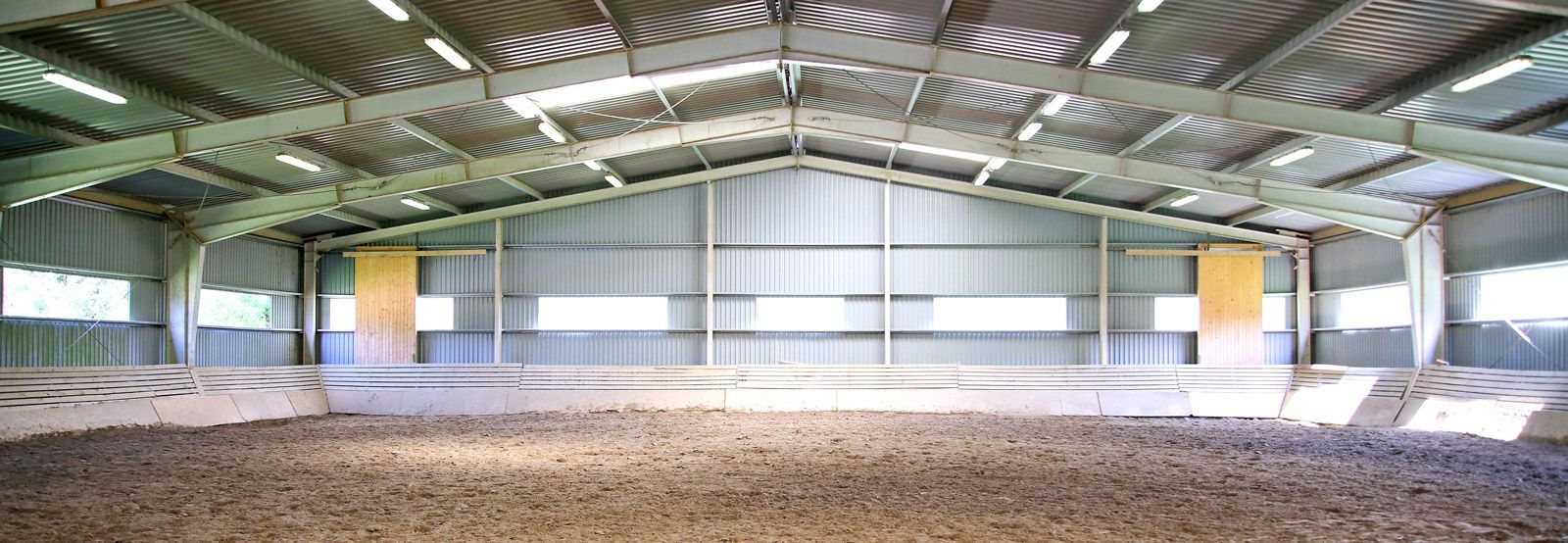 A large empty warehouse with a lot of dirt in it.