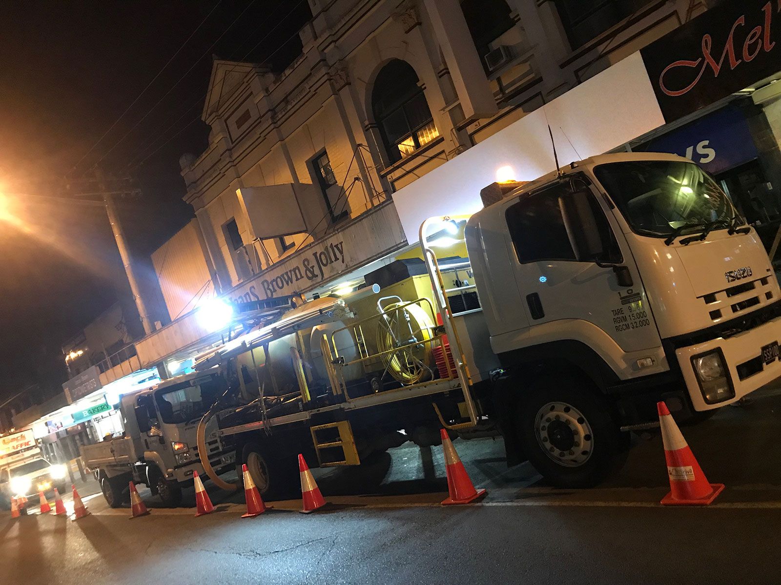 A truck is parked on the side of the road in front of a building.