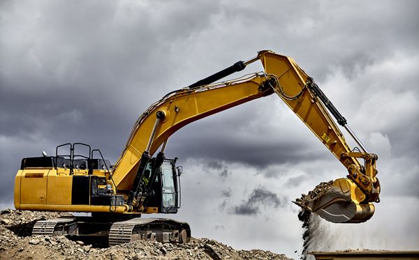 A yellow excavator is working on a construction site.