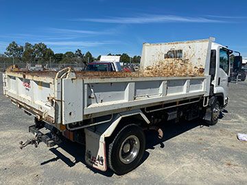 A white dump truck is parked in a parking lot.