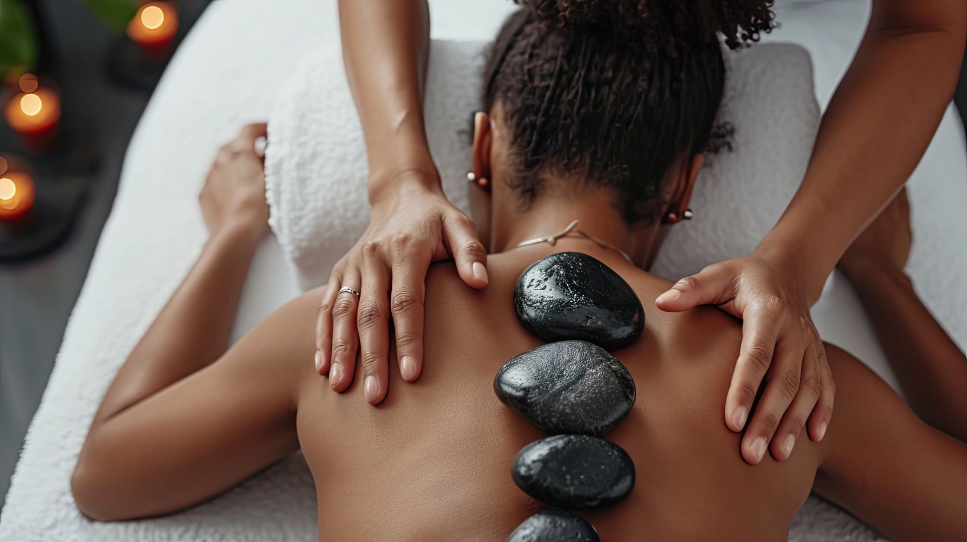 Spa massage with hot stones on a person's back in a relaxing treatment room