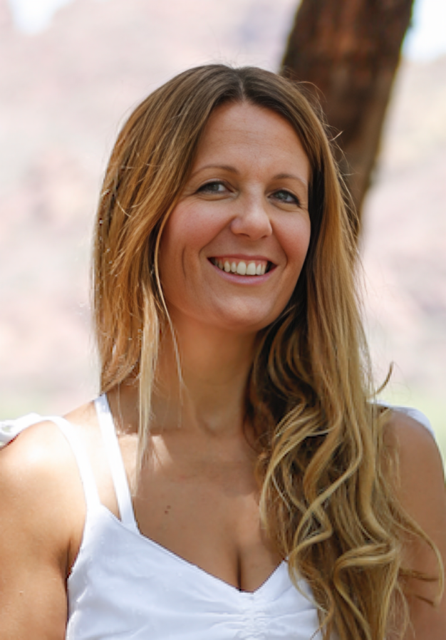 Smiling woman in a white sleeveless top outdoors with a soft blurred background