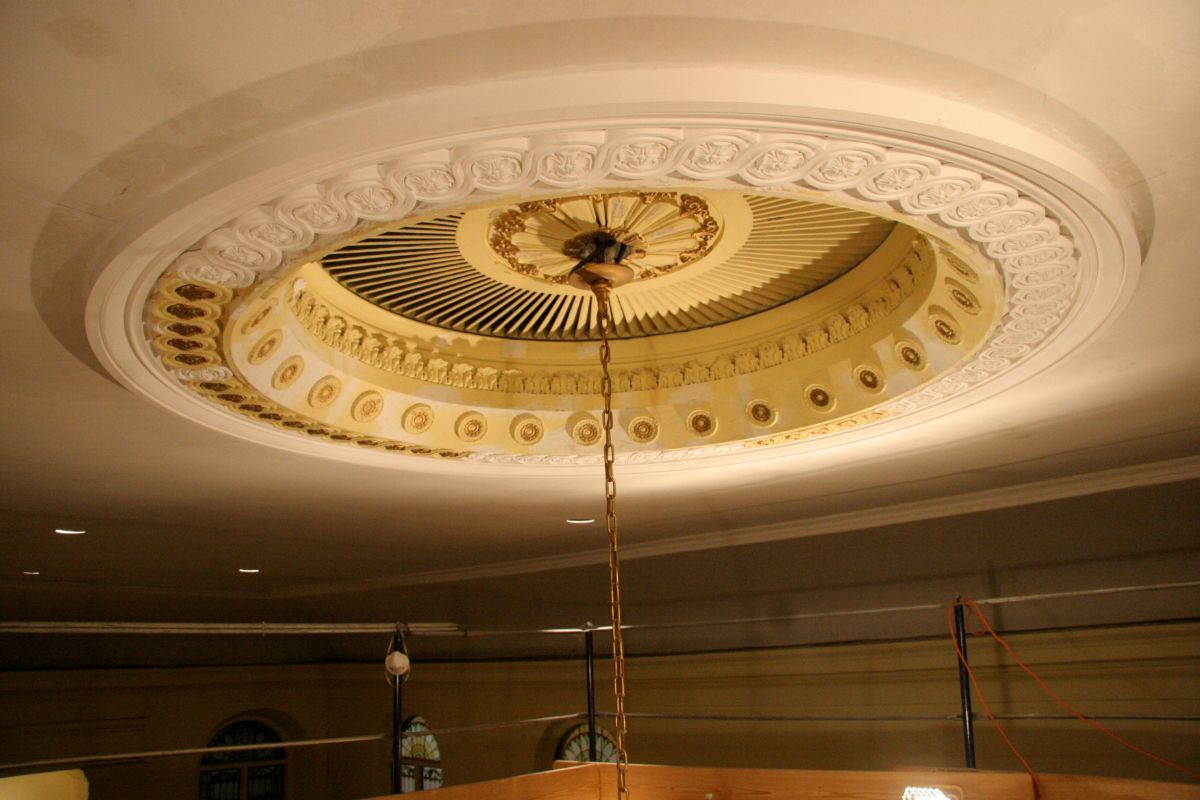 Ornate circular ceiling medallion with a hanging chain and warm recessed lighting