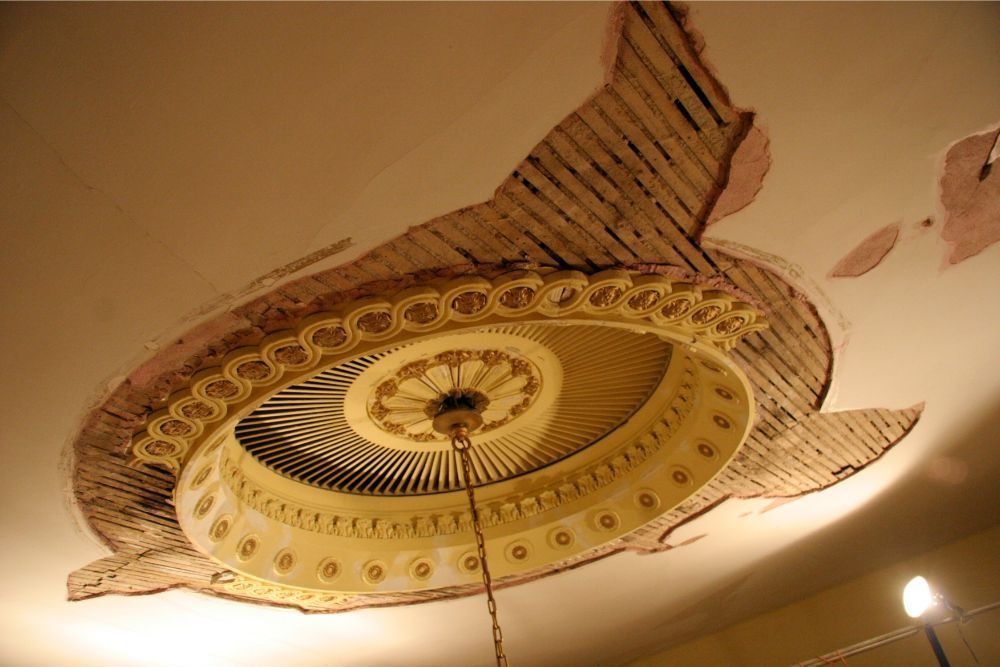 Ornate circular ceiling medallion with gold and cream details, viewed from below